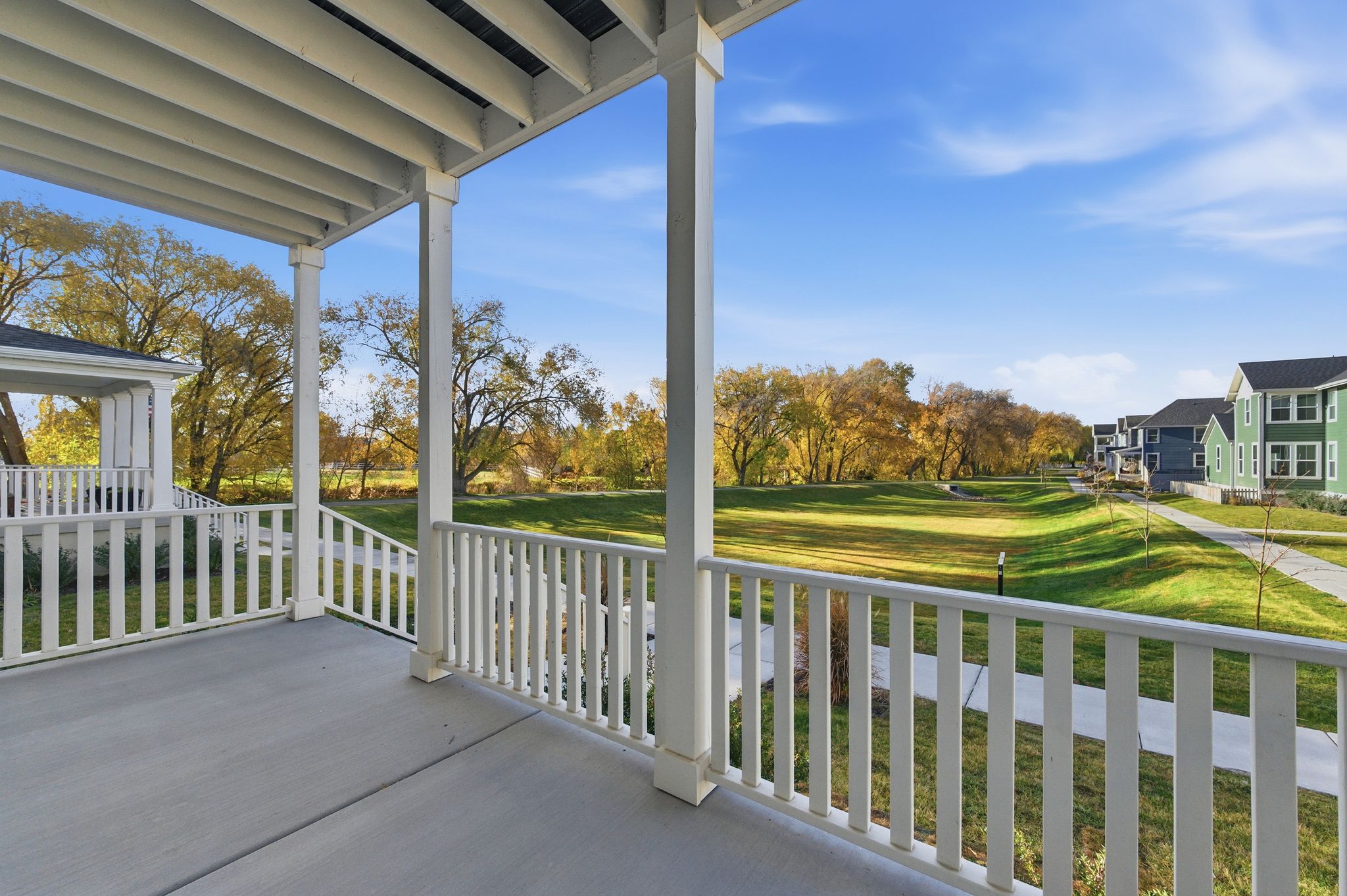Covered porch with white railings and columns, providing outdoor living space
