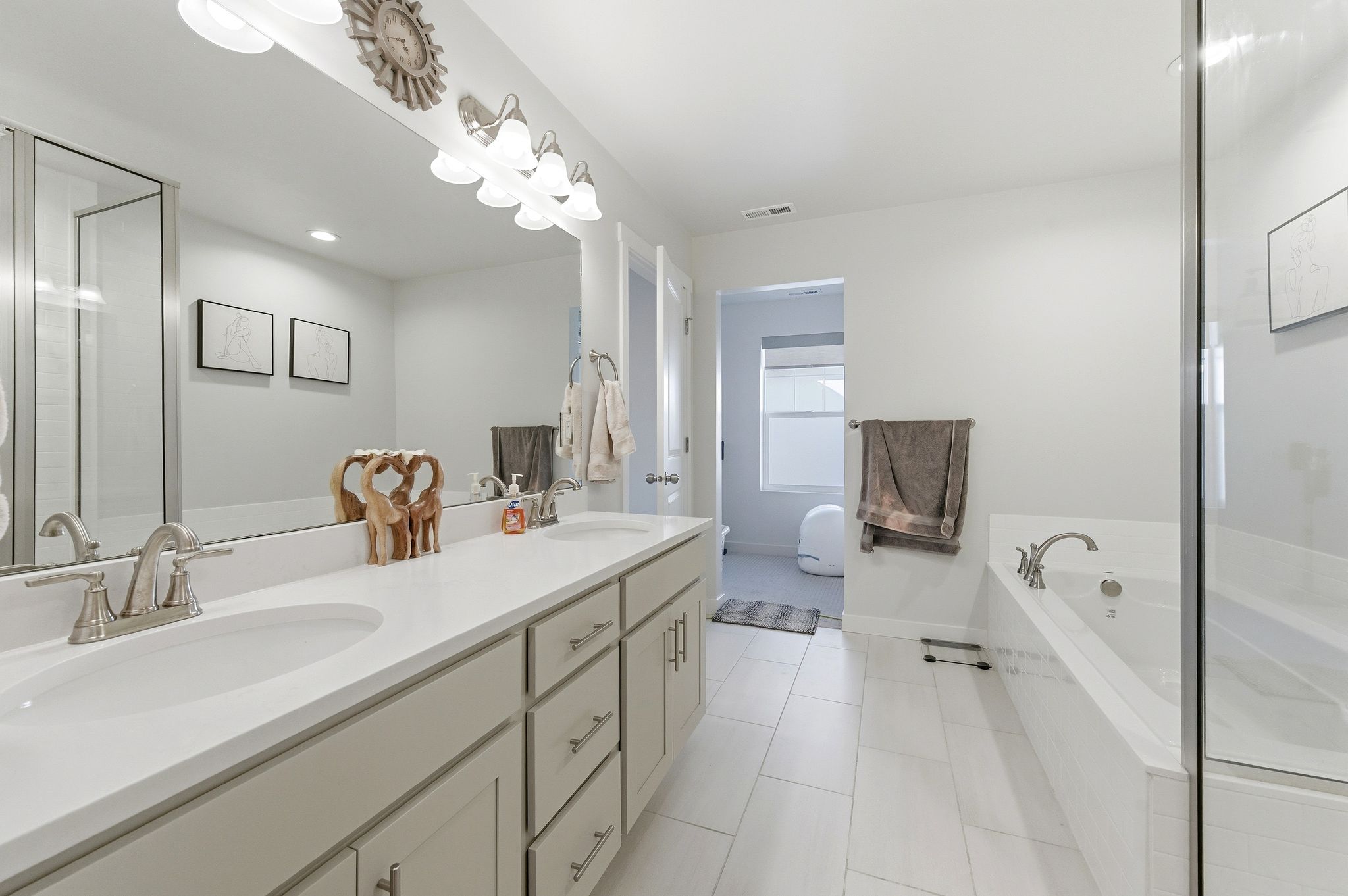 Double vanity with light cabinetry and white countertops