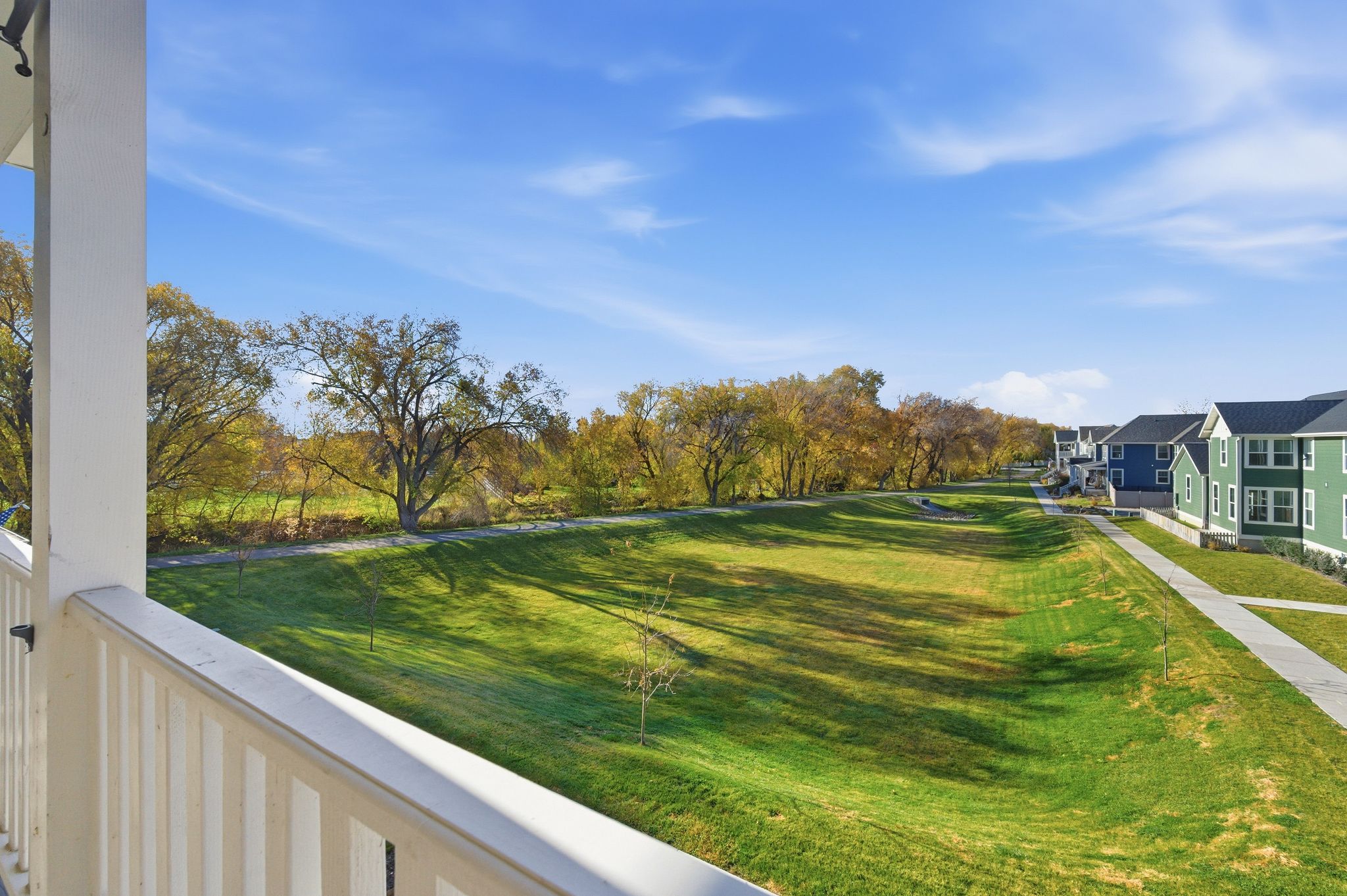 Expansive green space featuring mature trees and a paved pathway