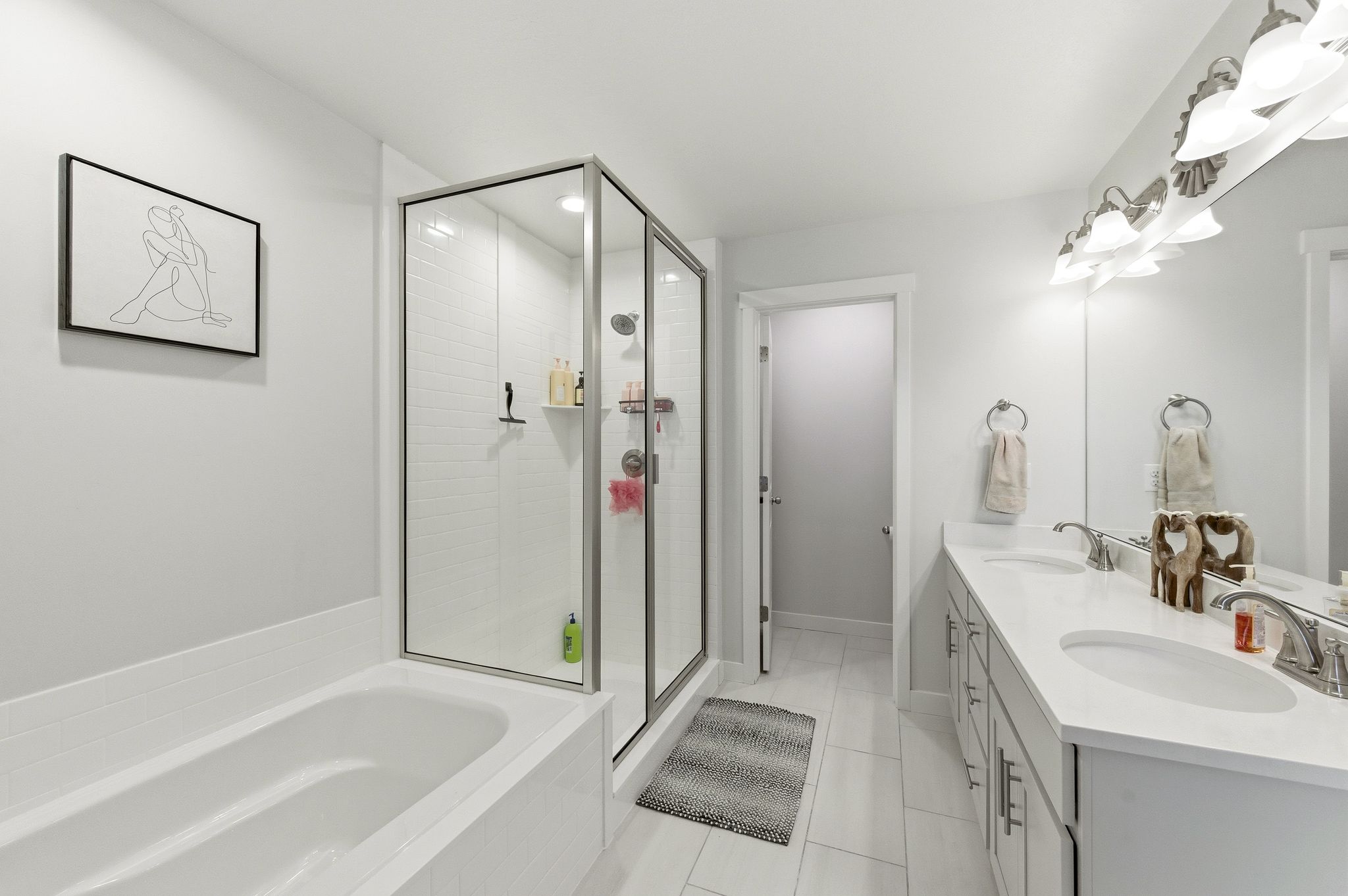 Bathroom featuring a tiled soaking tub and a clear glass shower enclosure with subway tile surround