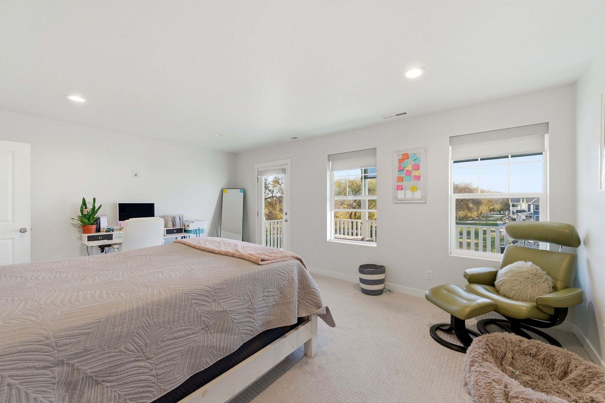 Bright room featuring two large windows with roller shades, recessed lighting, and light-toned carpeting
