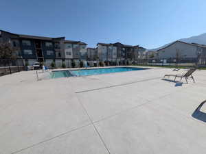 Community swimming pool featuring a large concrete deck