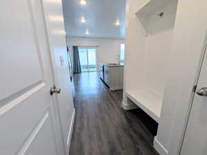 Entryway featuring a built-in bench and coat hook, wood-finish flooring, recessed lighting, and a sliding glass door