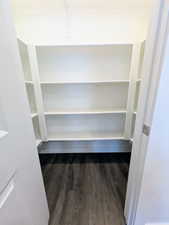 White shelving system with adjustable shelves, wood-finish flooring, and white trim