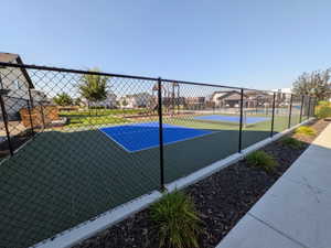 Fenced multi-sport court with a green and blue surface