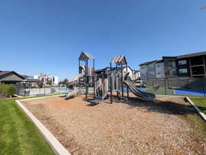 Outdoor playground area featuring multiple slides, climbing structures, and a wood chip surface