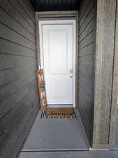 White entry door with paneling, sidelight, and brushed nickel hardware