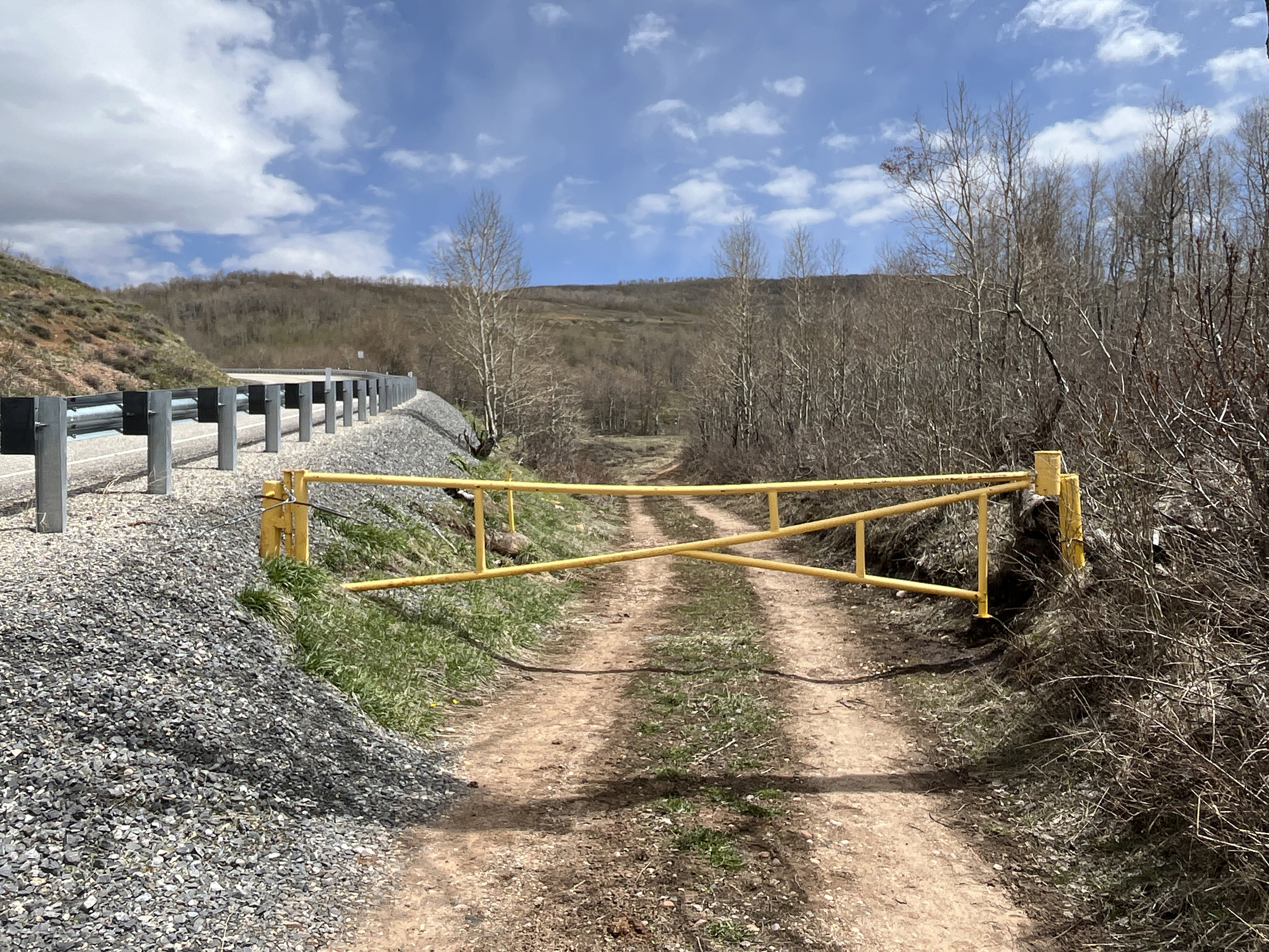Gated access road with natural surroundings, offering a private entrance to undeveloped land