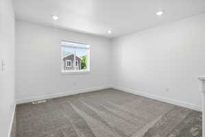 Room featuring a neutral gray carpet and bright white walls