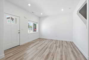 Open concept living space featuring wood-finish flooring and recessed lighting