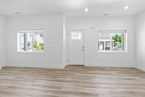 Spacious interior with wood-finish flooring, recessed lighting, and white walls