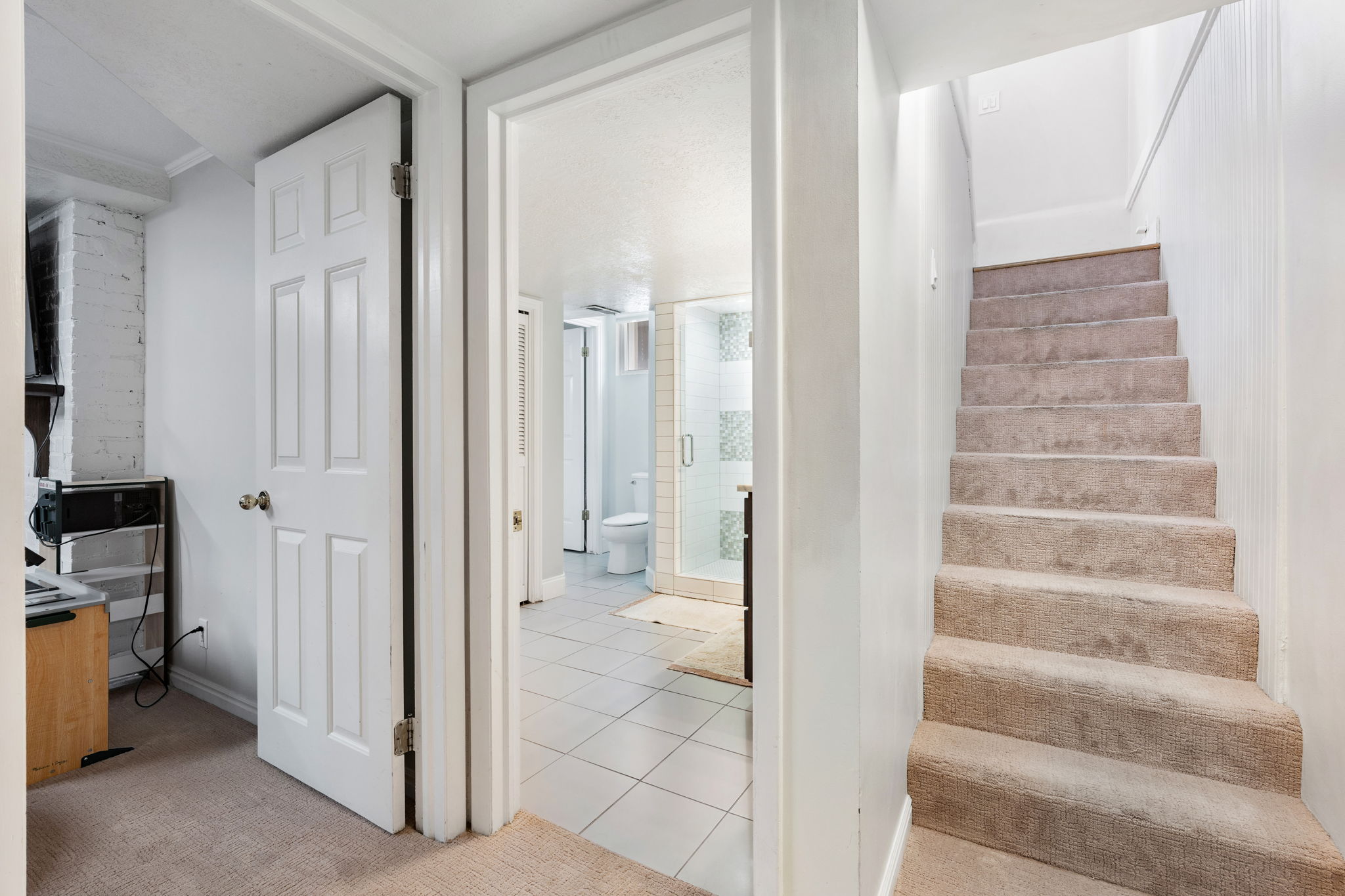 Carpeted staircase featuring white walls