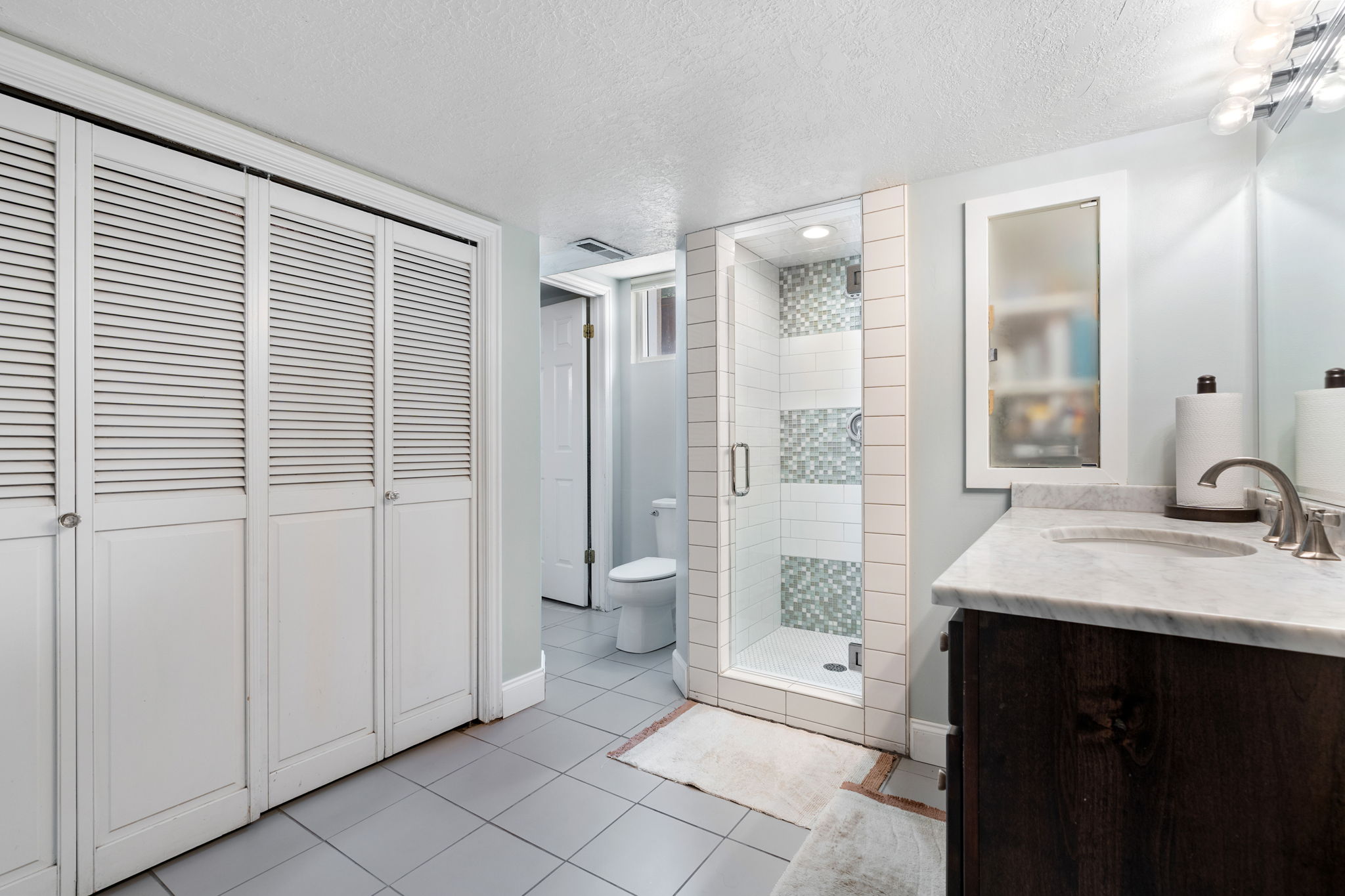 Bathroom featuring a glass-enclosed shower with decorative tile accents
