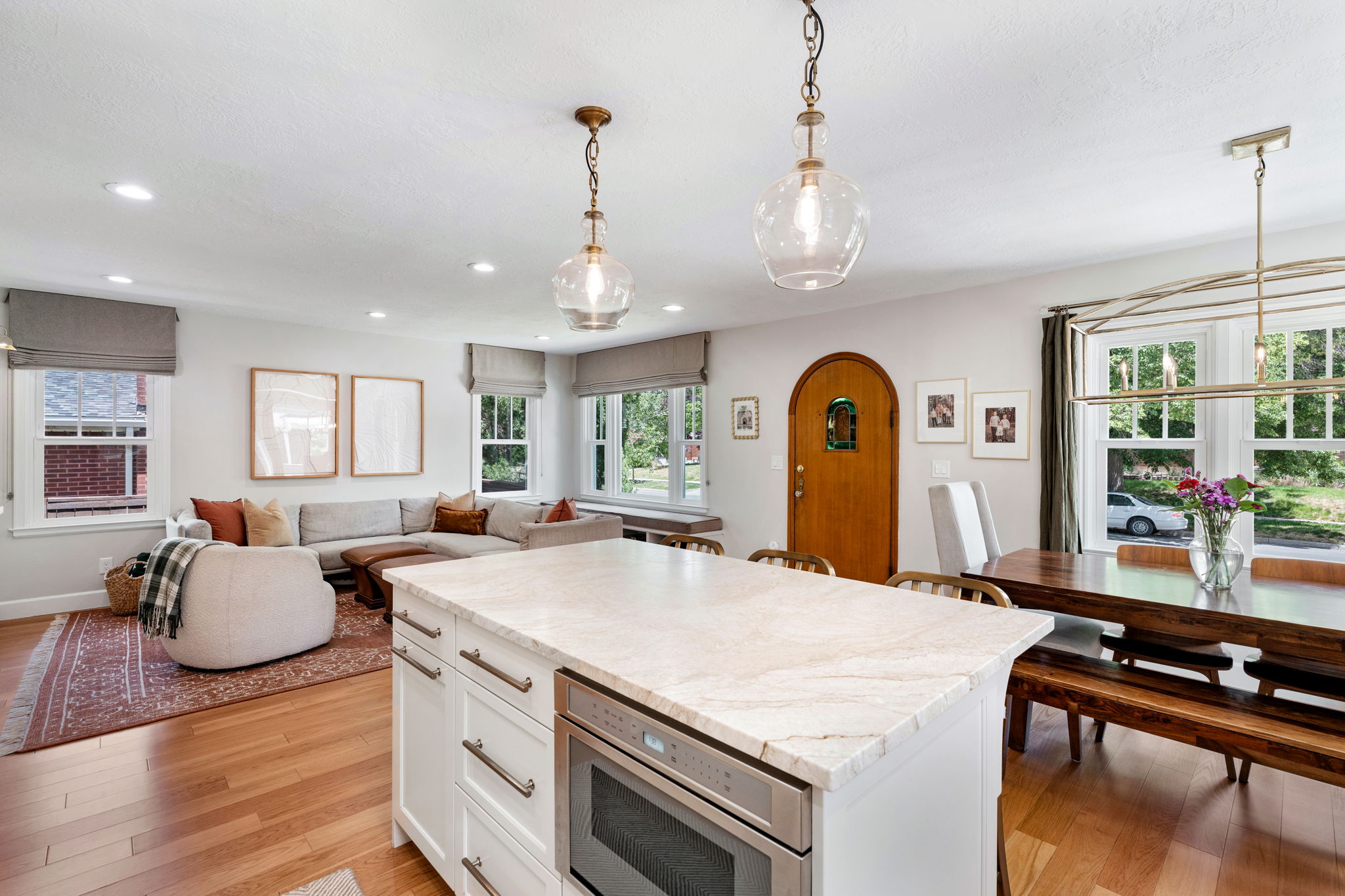 Kitchen island featuring a light-toned countertop, integrated microwave, and white cabinetry
