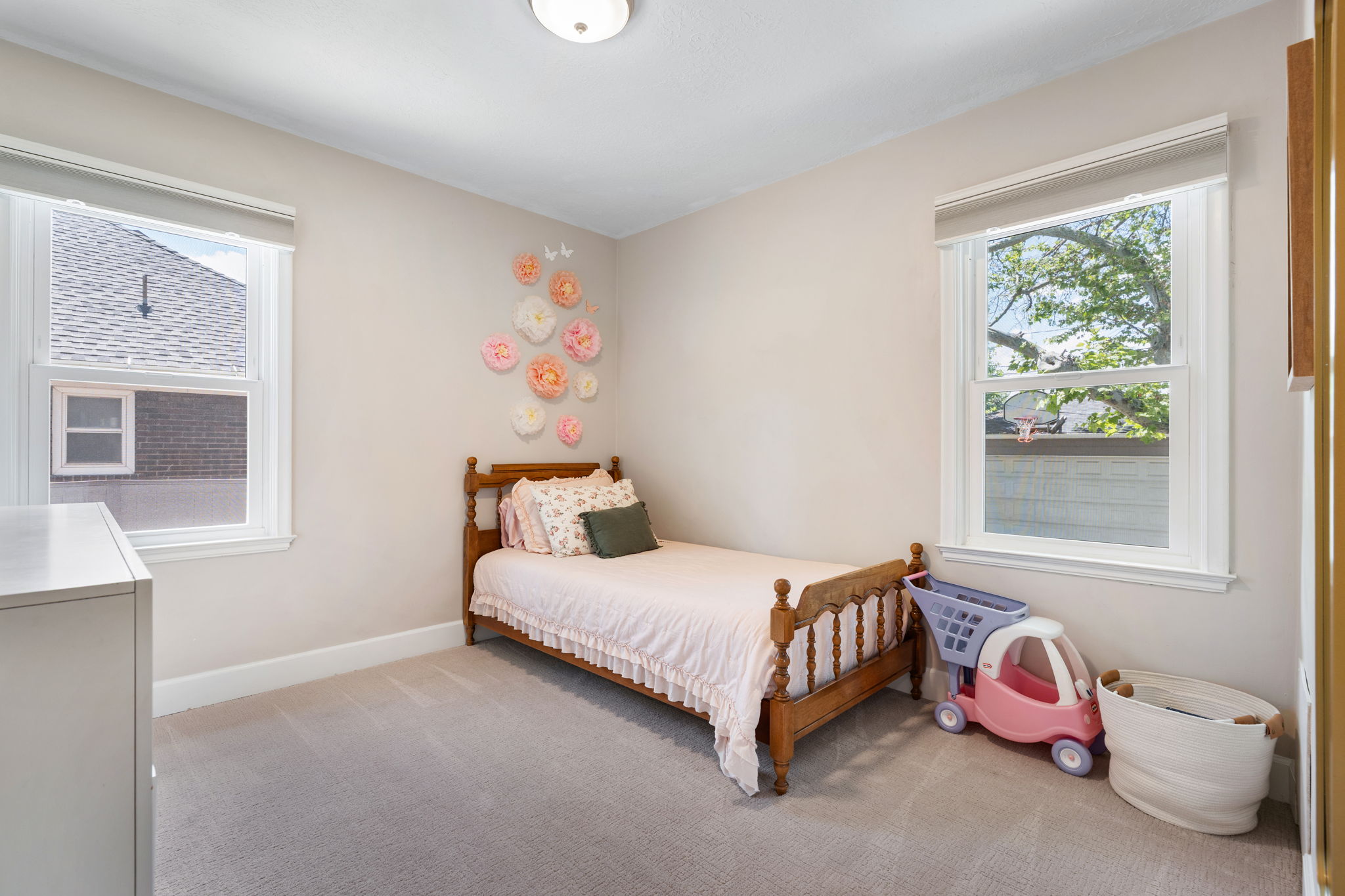 Carpeted room with two double-hung windows, neutral-toned walls, and a flush-mount ceiling light fixture