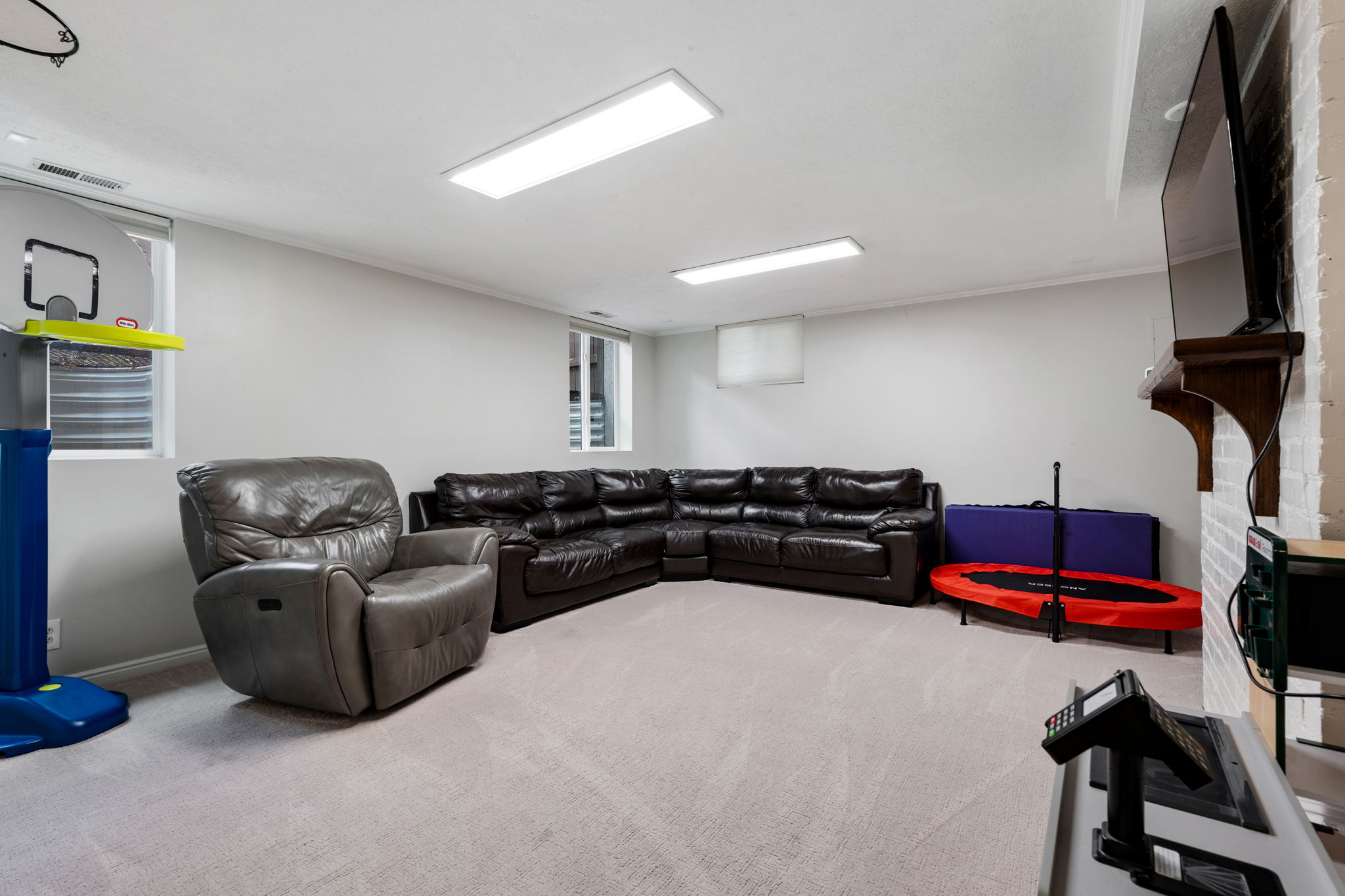 Spacious room featuring light-colored carpeting, recessed windows, and white painted walls