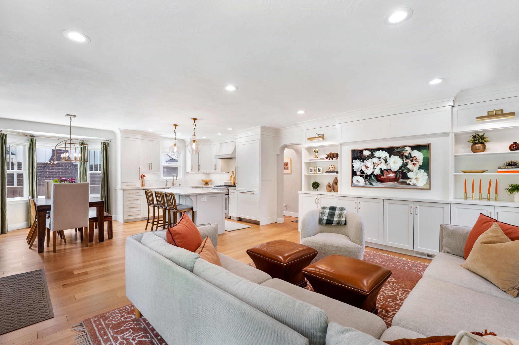 Open-concept living space featuring wood-finish flooring, recessed lighting, and a built-in media center with shelving