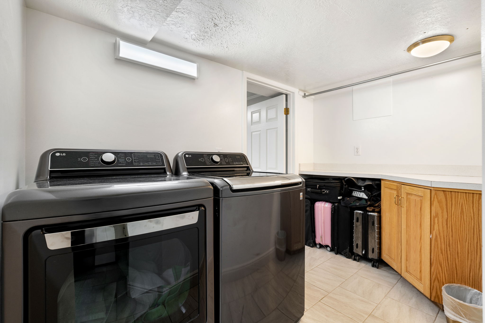 Dedicated laundry area featuring a washer and dryer, tile flooring, built-in cabinetry, and a countertop workspace