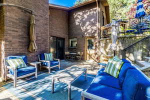 Spacious outdoor patio featuring brick exterior, a multi-level design, concrete steps, and a privacy wall