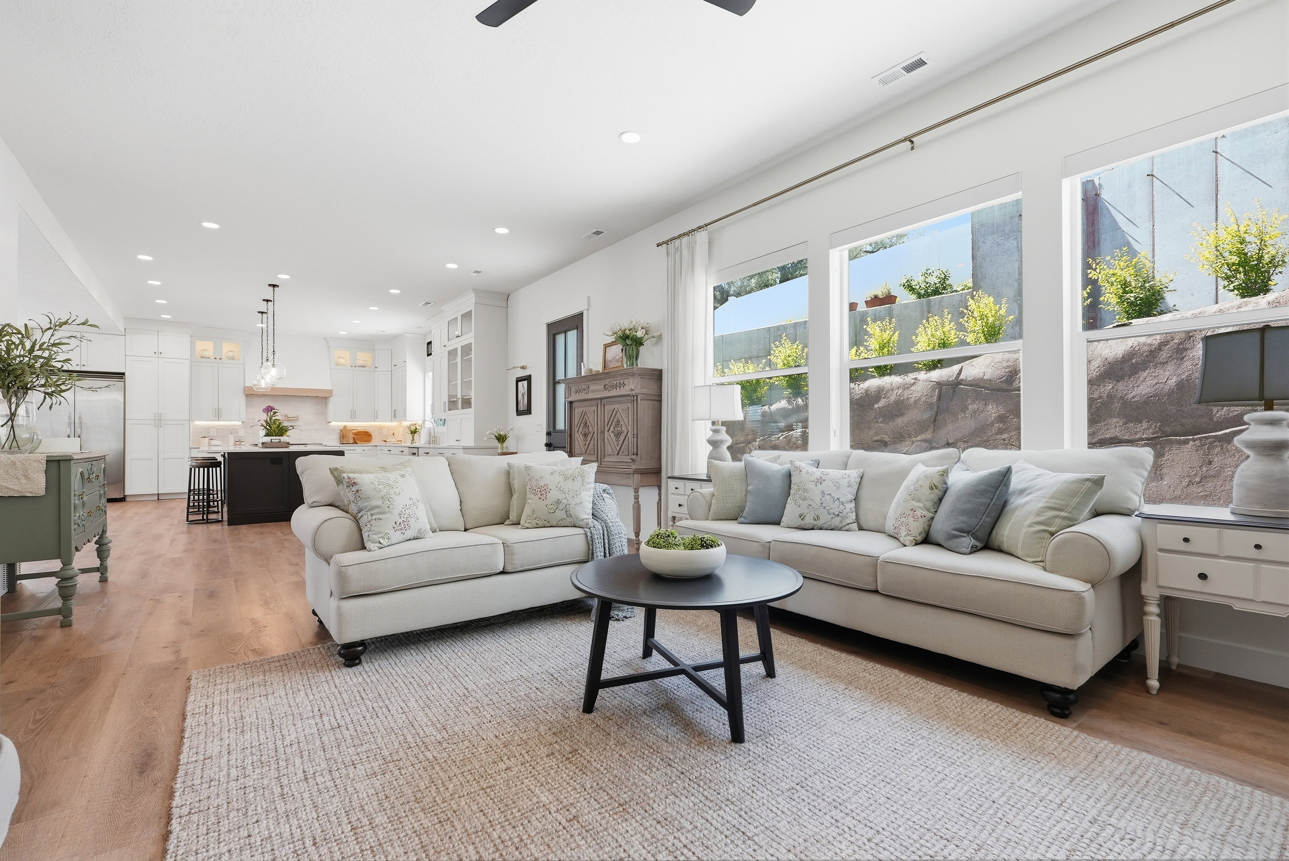 Bright, open-concept living area featuring LVP flooring, recessed lighting, and large windows