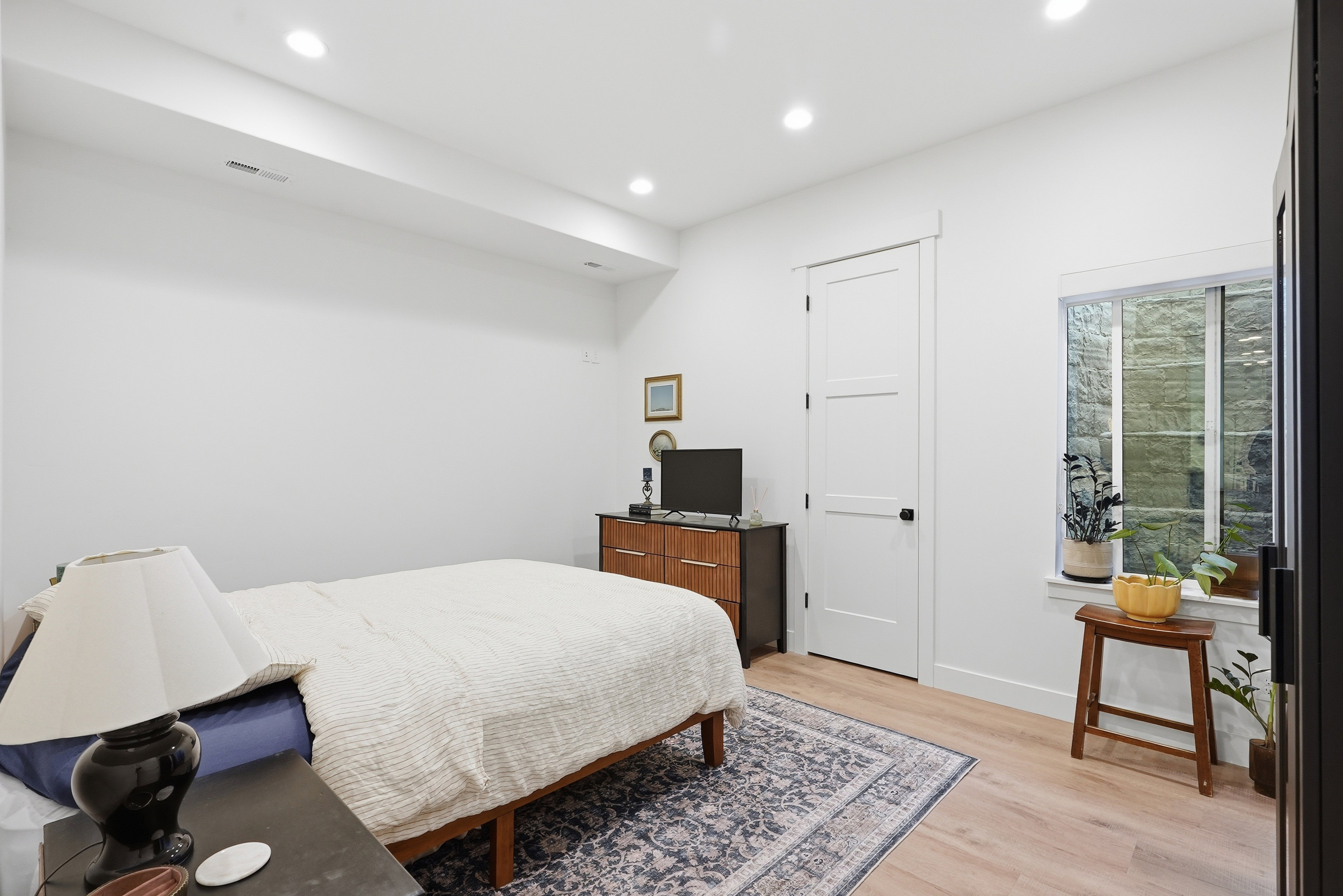 Bright bedroom featuring LVP Flooring and recessed lighting