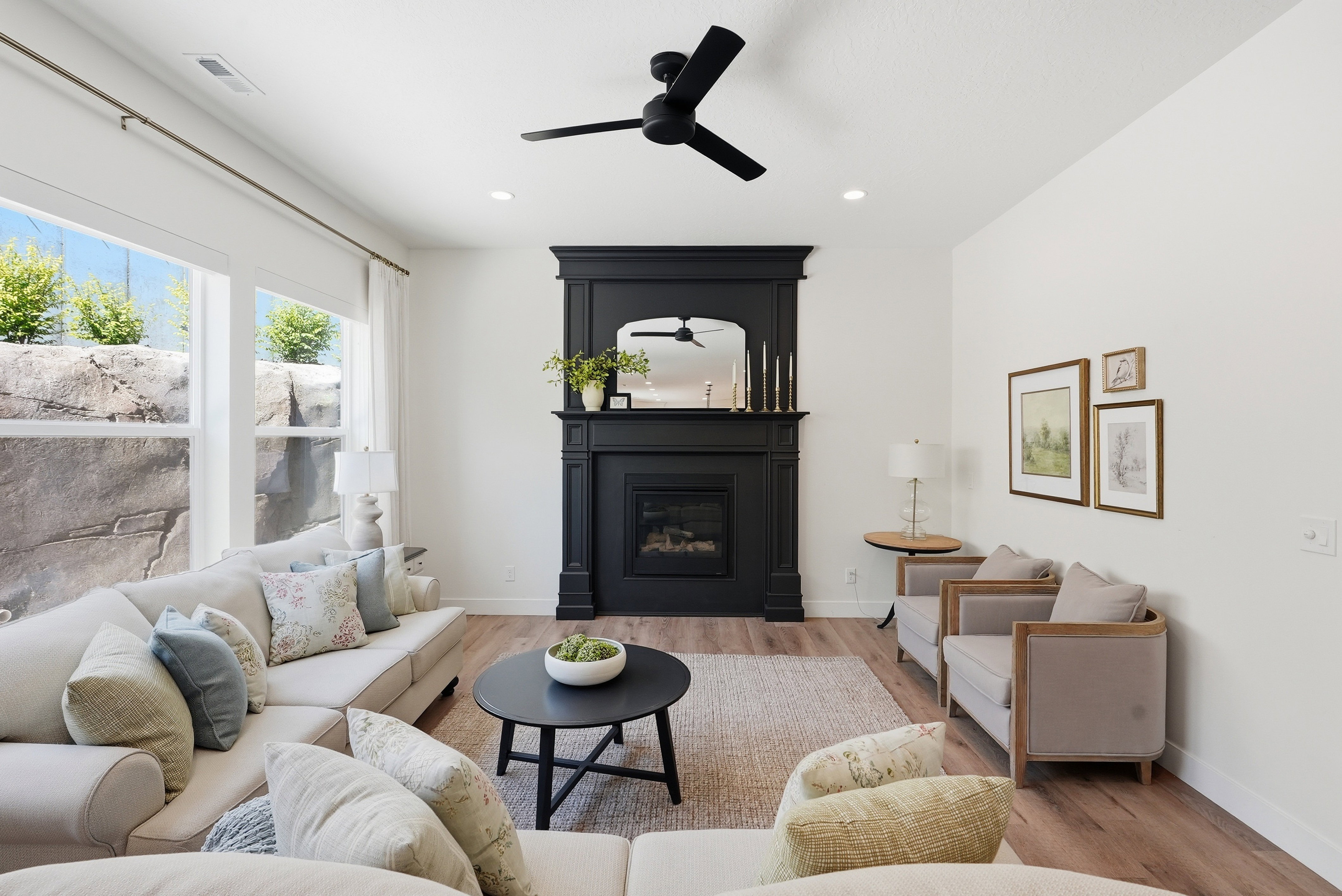Living area featuring a black fireplace with a detailed mantel, wood-finish flooring, recessed lighting, and a modern ceiling fan