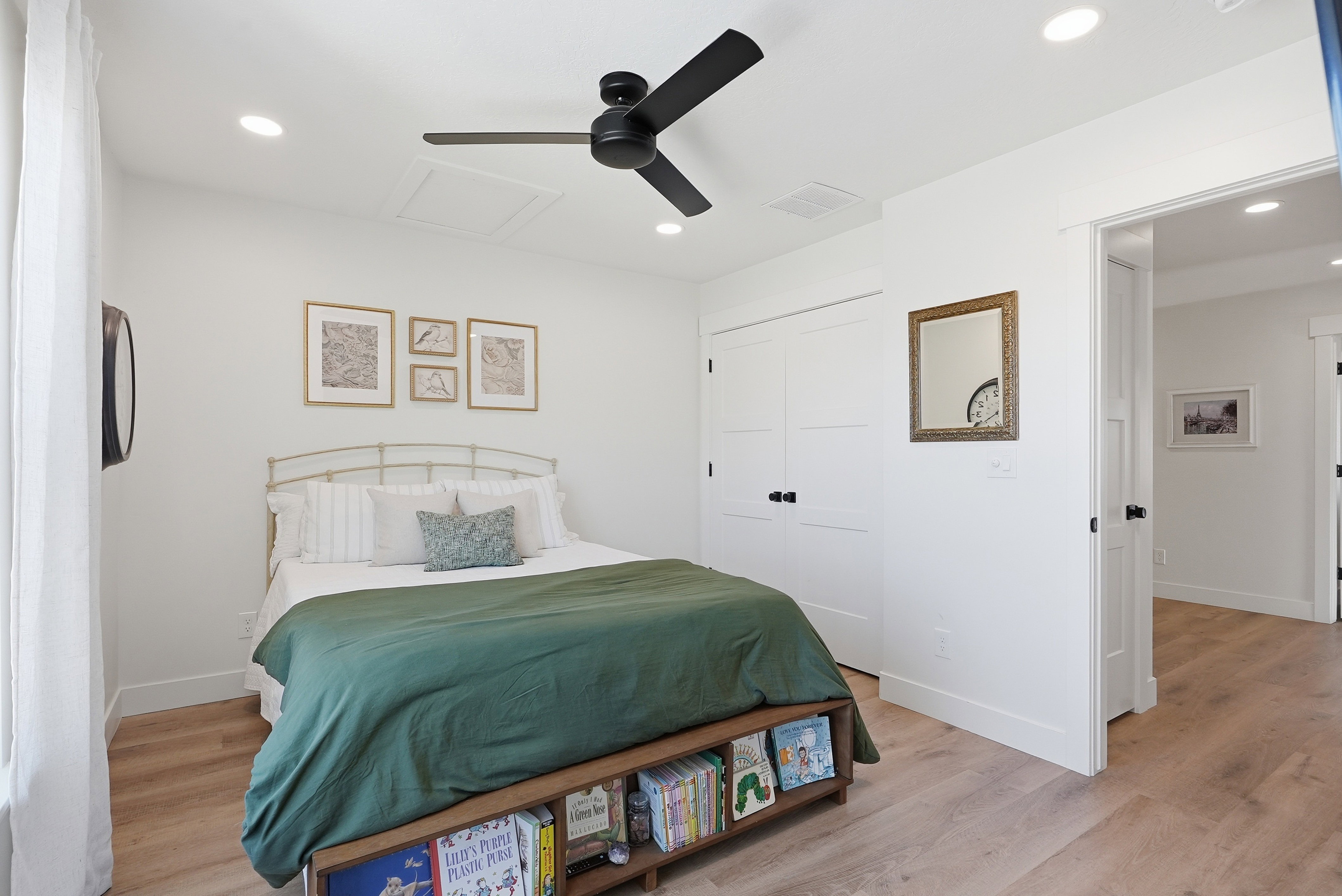 Light-toned LVP flooring provides a bright base for this room featuring a ceiling fan with black blades, recessed lighting, and white walls