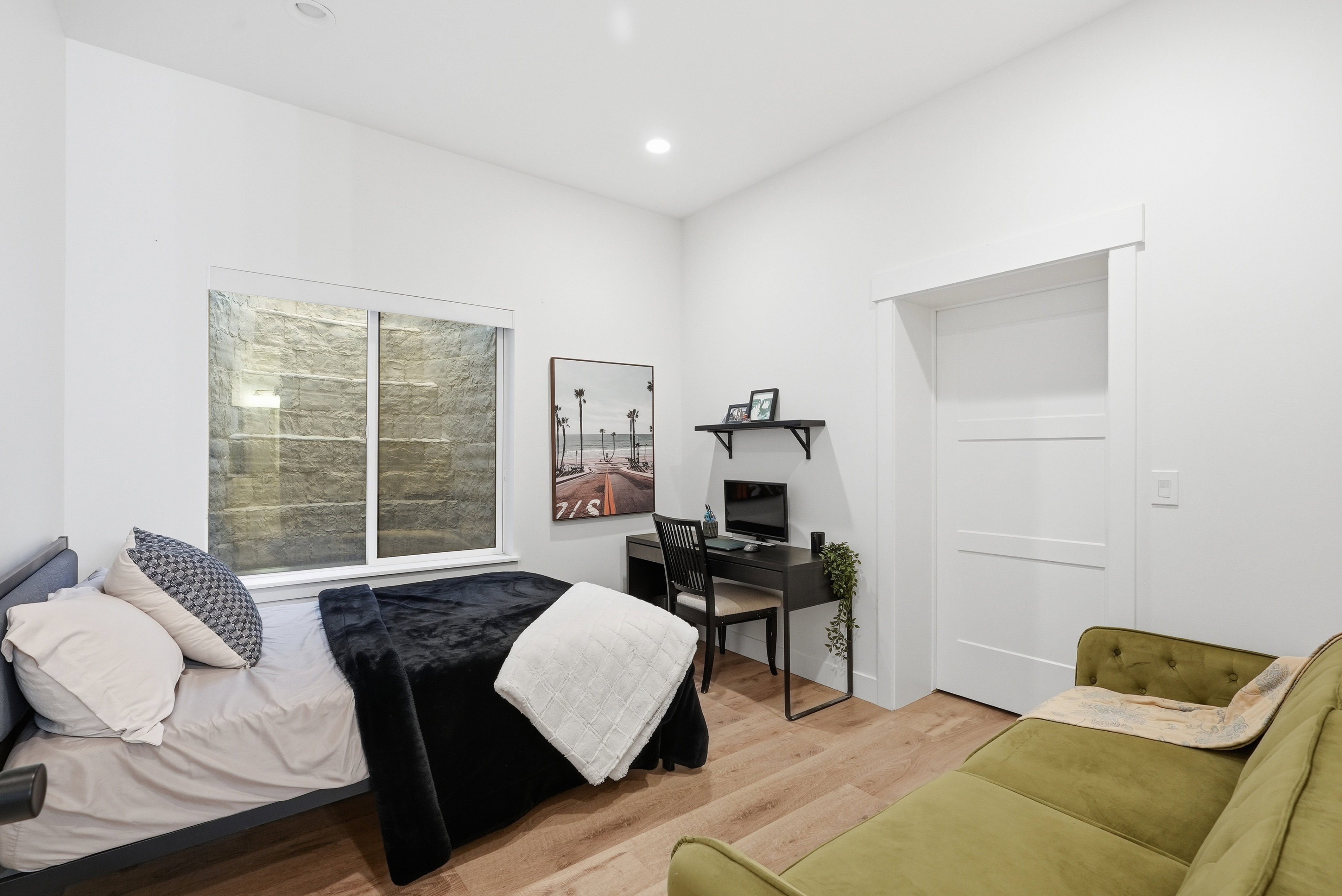 Bright interior space featuring recessed lighting, LVP finish flooring, a white window frame, and a white interior door with horizontal paneling