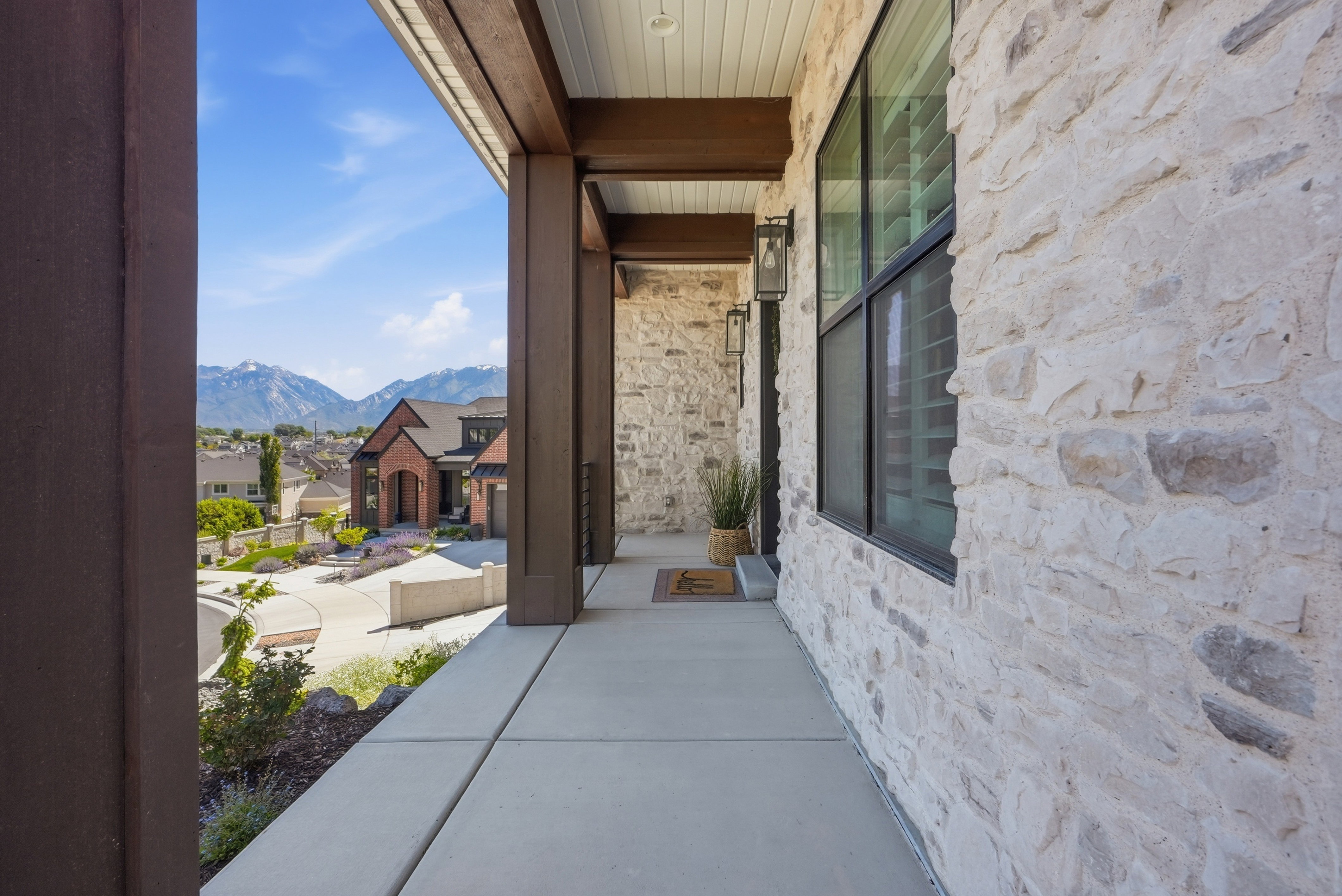 Covered concrete porch with robust wood-finish beams