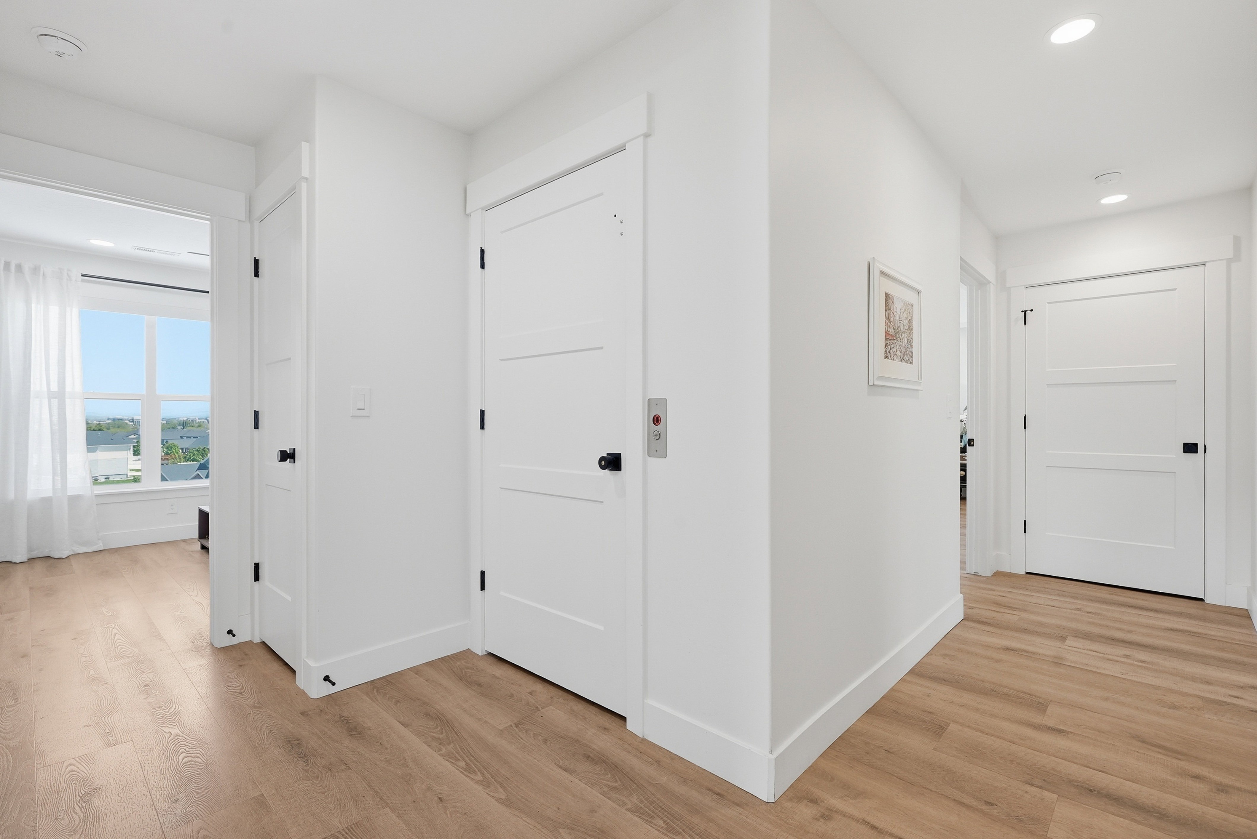 Hallway featuring LVP flooring, white walls, and recessed lighting