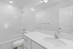 Modern bathroom featuring a white vanity with an integrated sink and light-toned countertop