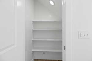 Built-in pantry shelving featuring five levels of storage, recessed lighting, and wood-finish flooring