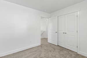 Interior room featuring neutral carpeting, white walls, and white baseboards