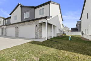 Contemporary townhome exterior featuring light siding and stacked stone accents