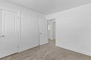 Neutral-toned carpeting complements the white walls and trim throughout this interior space