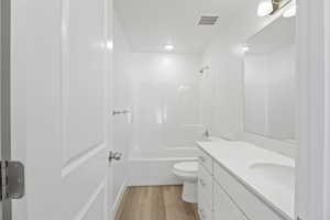 Bathroom featuring a white vanity with a light-colored countertop, an integrated sink, and brushed nickel hardware