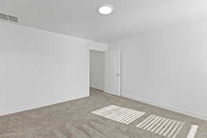 Neutral-toned wall-to-wall carpeting complements the bright white walls and trim