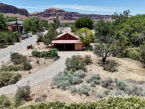 Red-sided structure featuring a covered porch with a metal roof
