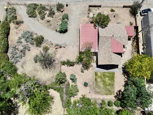 Property featuring a red metal roof section, a shingled roof section, and a gravel driveway