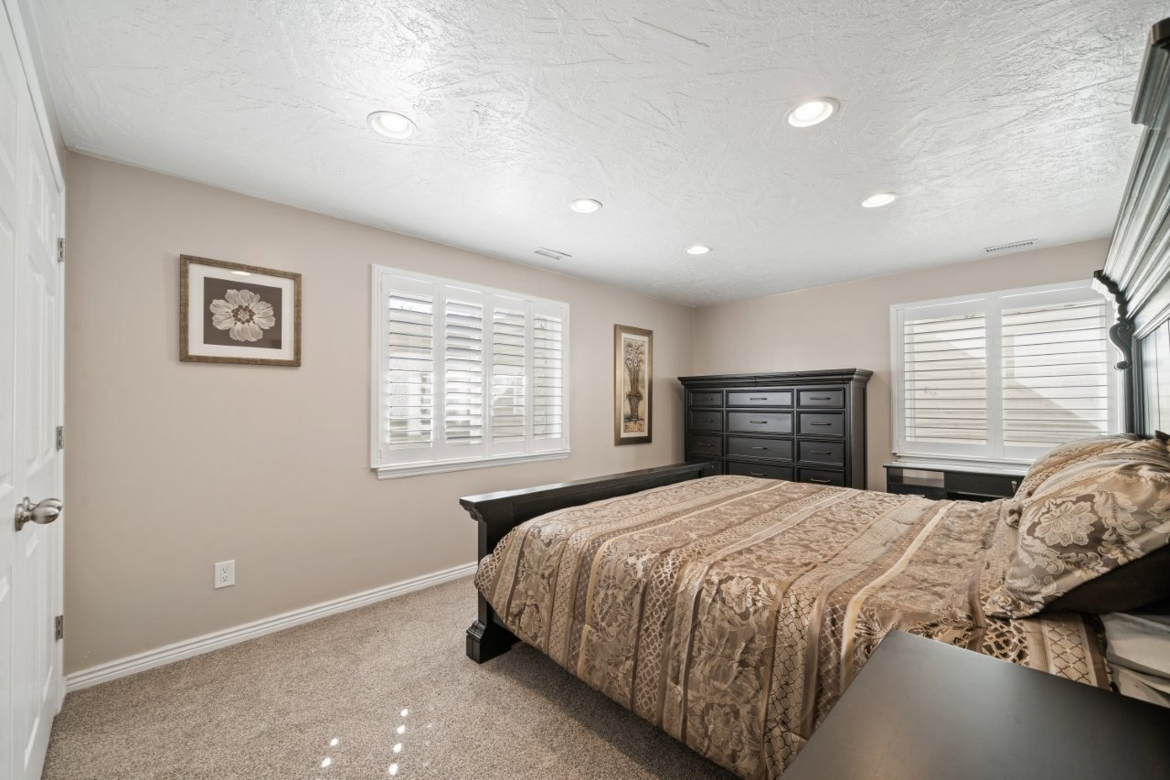 Bedroom featuring light colored carpet, recessed lighting, and a textured ceiling