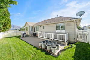 Back of house with roof with shingles, a fenced backyard, a patio area, and a gate