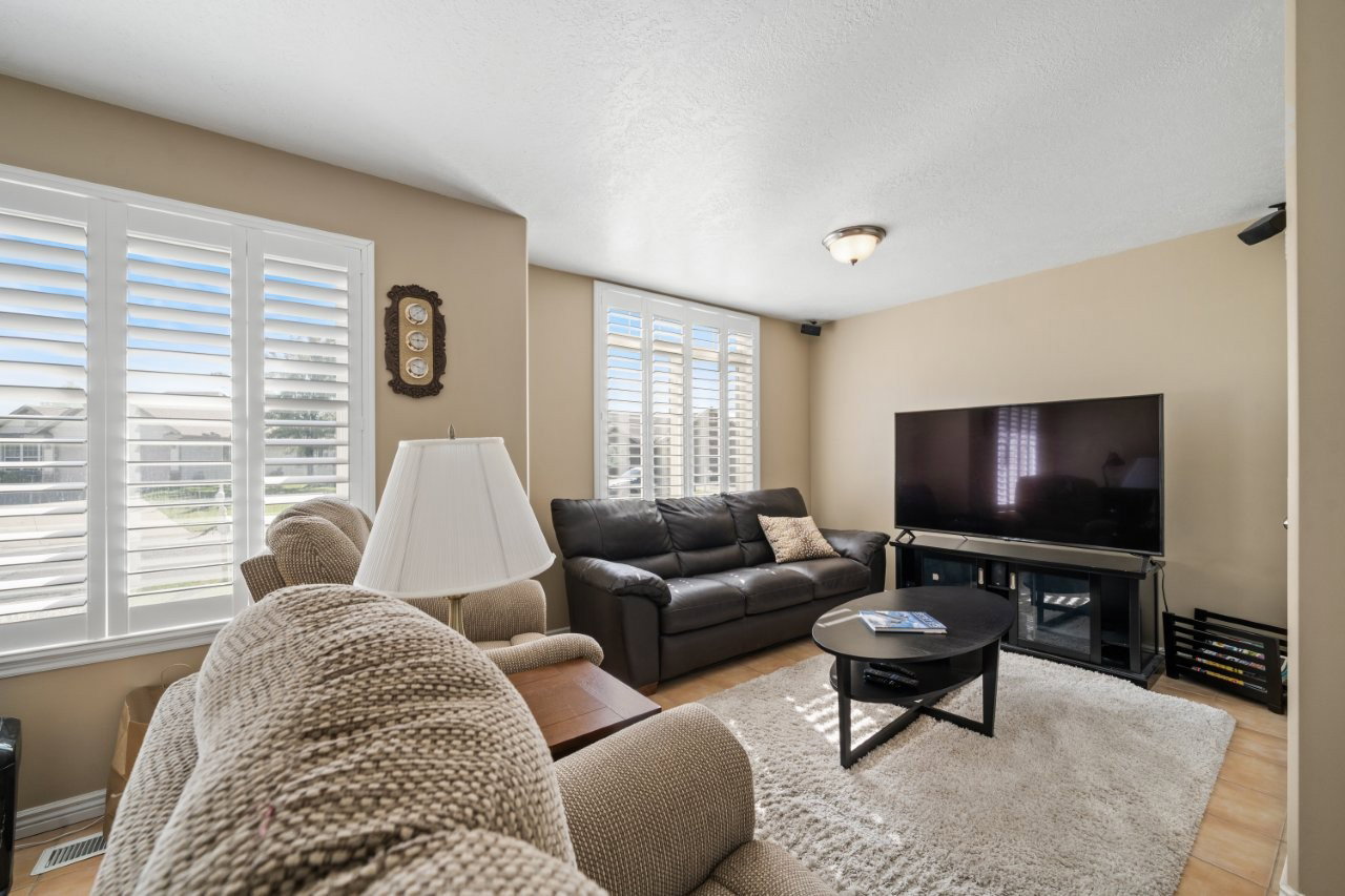 Living room with a textured ceiling and light wood-style flooring
