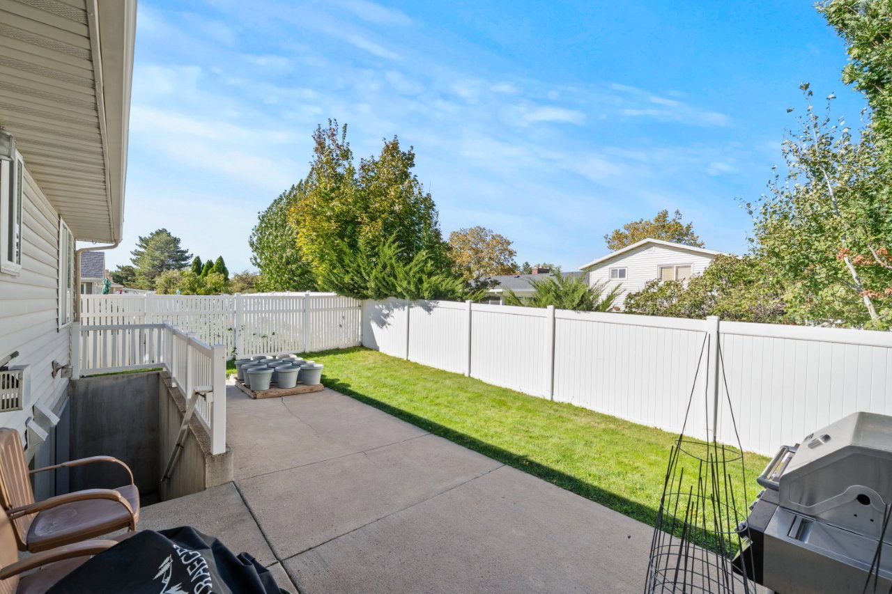 Fenced backyard featuring a patio and area for grilling