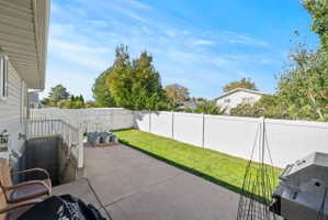 Fenced backyard featuring a patio and area for grilling