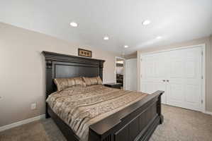 Bedroom featuring recessed lighting, light colored carpet, a closet, and a textured ceiling