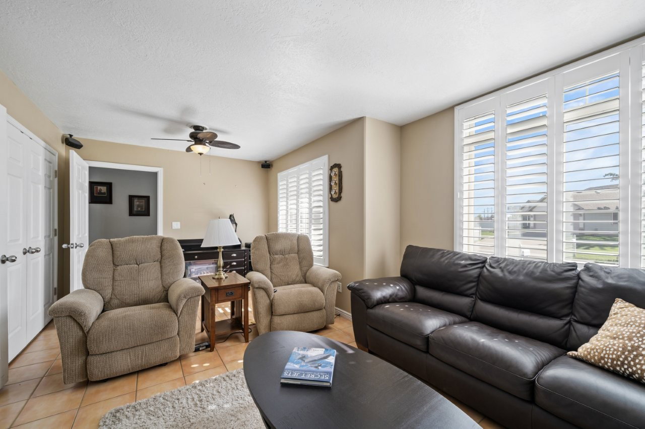 Living room featuring tile patterned floors, a ceiling fan, and a textured ceiling
