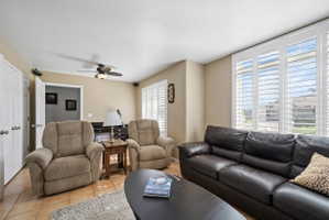 Living room featuring tile patterned floors, a ceiling fan, and a textured ceiling