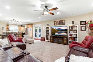 Spacious living area featuring neutral carpeting and recessed lighting