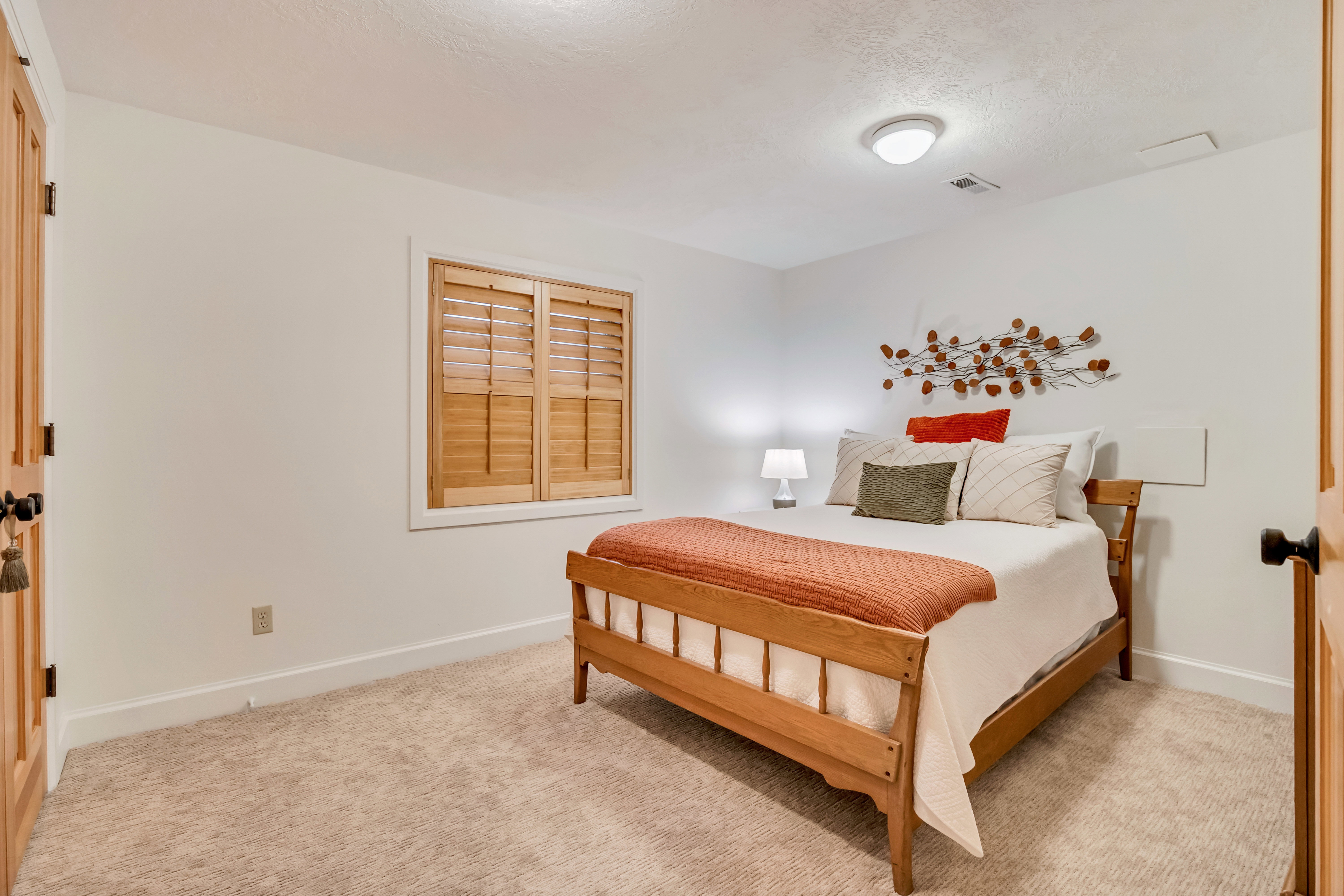 Neutral tone carpeted room with white walls and baseboards