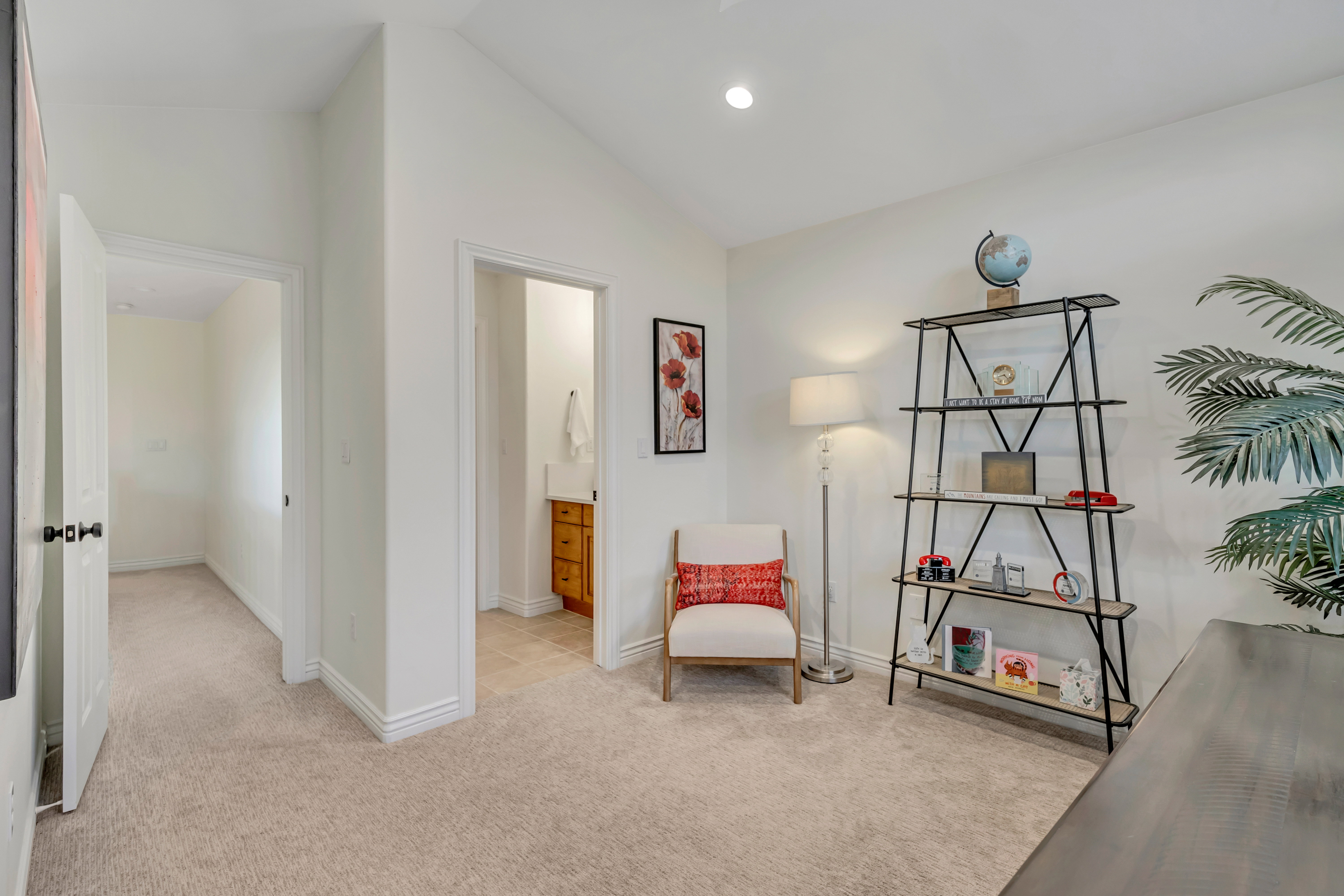 Carpeted room with recessed lighting and a doorway opening to a hallway